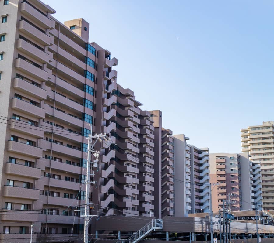 都市の高層マンションの一角。多くのバルコニーが特徴的な建物群。